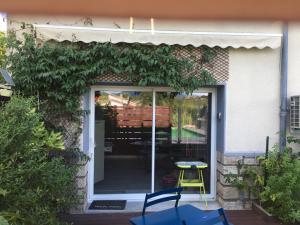 a door to a house with a yellow chair on a patio at Les Balusets in Vinezac