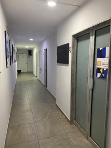 a hallway of a hospital with doors and a tile floor at Hotel Matamoros in Tepatitlán de Morelos