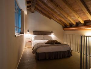 - une chambre avec un lit dans une pièce dotée de plafonds en bois dans l'établissement Locanda Cà dei Santi, à Induno Olona