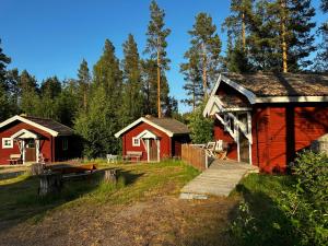 un grupo de cabañas en un campo con árboles en Ramsjö Camping Stuga, en Ramsjö