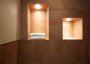un bagno con due specchi e un mucchio di asciugamani di Locanda Cà dei Santi a Induno Olona