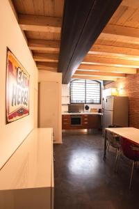 een keuken met een tafel en een koelkast bij Luxury industrial apt vicino al centro con garage in Brescia