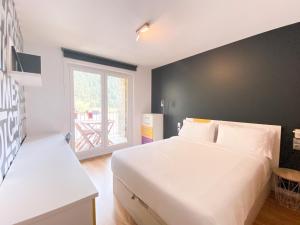 Un dormitorio con una gran cama blanca y una ventana en 3 Hab en Arinsal a PIE DE PISTAS - Terraza con Vistas - 1 plaza Parking Incluido, en Arinsal