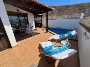een patio met stoelen en een zwembad bij Casa Mararía in Gran Tarajal