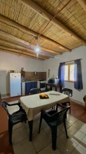 Una mesa y sillas en una habitación con cocina. en By Lela, en Tinogasta