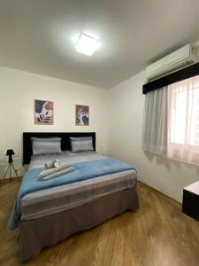 Apartamentos & Flats La Residence Paulista في ساو باولو: غرفة نوم مع سرير مع دمية دب ملقاة عليه