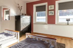 a bedroom with a bed and two windows and a dresser at Haus Gretchen in Bömighausen