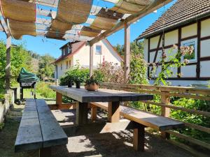a wooden picnic table under a pergola at Haus Gretchen in Bömighausen