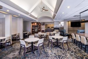 a dining room with tables and chairs and a flat screen tv at Residence Inn Denver Southwest/Lakewood in Lakewood