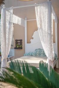 1 dormitorio con 1 cama con cortinas y una planta verde en Can Content - Playa de Muro, en Muro