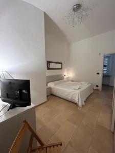 a bedroom with a bed and a flat screen tv at La Marchesa in Magliano Alfieri
