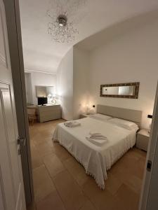 een slaapkamer met een wit bed en een spiegel bij La Marchesa in Magliano Alfieri