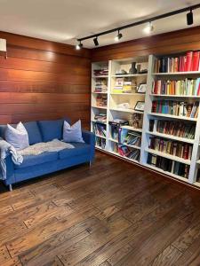 a living room with a blue couch and book shelves at Nyoppusset og romslig leilighet med 6 soveplasser i et familievennlig område in Sarpsborg