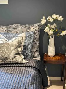 a bedroom with a bed and a vase of flowers on a table at Nyoppusset og romslig leilighet med 6 soveplasser i et familievennlig område in Sarpsborg