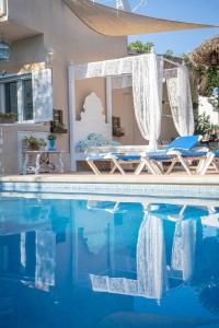 穆羅的住宿－Can Content - Playa de Muro，一个带2把躺椅和镜子的游泳池
