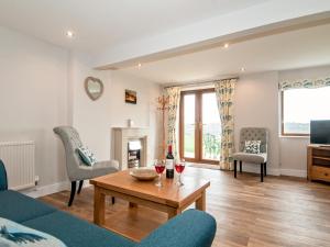 a living room with a couch and a table at Silver Birch Lodge in Horsley