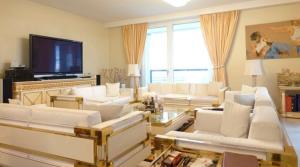 a living room with white furniture and a flat screen tv at Luxury Diplomat-Penthouse - UNO City Vienna in Vienna