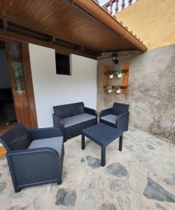eine Terrasse mit 3 Stühlen, einem Tisch und einer Bank in der Unterkunft Vv Casa Muya in Icod de los Vinos
