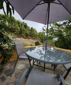 einen Tisch und Stühle mit Sonnenschirm auf einer Terrasse in der Unterkunft Vv Casa Muya in Icod de los Vinos