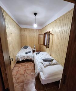 two beds in a room with wooden walls at Vv Casa Muya in Icod de los Vinos