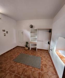 um quarto vazio com um frigorífico e piso em azulejo em Vv Casa Muya em Icod de los Vinos