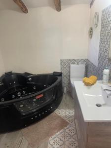 baño con bañera negra junto a un lavabo en Finca el Atardecer-Luna en Los Santos de Maimona