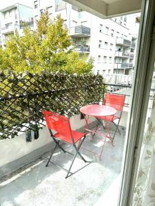 twee rode stoelen en een tafel op een balkon bij BIG logement , JO2024, stade de France, PARIS, métro , parking gratuit in Saint-Denis