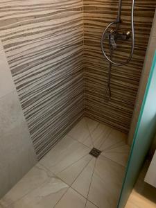 a shower with a wooden wall and a shower head at Apartman AM Sarajevo in Sarajevo