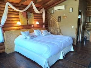 ein Schlafzimmer mit einem großen weißen Bett in einem Zimmer in der Unterkunft Pualy Resort & Spa in Belén de Escobar
