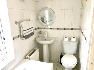La salle de bains blanche est pourvue de toilettes et d'un lavabo. dans l'établissement The Washington Sleeps 10 people park 4 cars, à Bristol