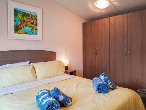 ein Schlafzimmer mit einem Bett mit blauen Kissen darauf in der Unterkunft Glenbeagles Lodge in Dollar