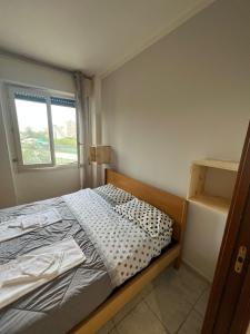 een kleine slaapkamer met een bed en een raam bij Mya’s Home in Cinisello Balsamo