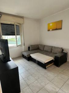 a living room with a couch and a tv at Mya’s Home in Cinisello Balsamo