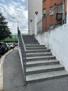 a set of stairs next to a building with cars at Mya’s Home in Cinisello Balsamo