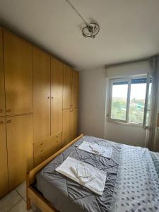 a bedroom with a bed with wooden cabinets and a window at Mya’s Home in Cinisello Balsamo