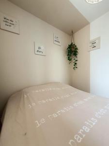een slaapkamer met een wit bed met borden aan de muur bij Au bord de la plage du Grazel in Gruissan