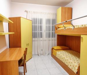 Kleines Zimmer mit Etagenbetten und einem Schreibtisch. in der Unterkunft La Casa di Bonaria in Sestu