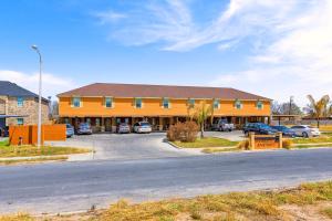 un bâtiment orange avec des voitures garées dans un parking dans l'établissement Hummingbird Haven 2 Cozy Comfort Haven - Parking at No Extra Cost, à Pharr