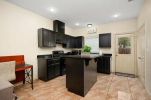 cocina con armarios negros y encimera negra en Hummingbird Haven 2 Cozy Comfort Haven - Parking at No Extra Cost, en Pharr