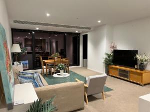 a living room with a couch and a television at Quiet CBD 3b2b apartment + free parking in Melbourne