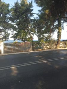 una calle vacía con una valla y un árbol en Bluetopia studio, en Skala Kallirakhis