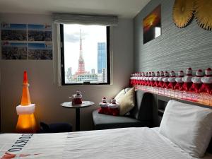 Habitación de hotel con cama, silla y ventana en Henn na Hotel Tokyo Hamamatsucho en Tokio