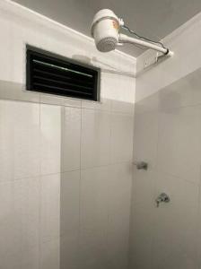 a white bathroom with a shower and a window at Apartamento Acogedor y muy central en Bogotá in Bogotá