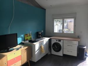 eine Waschküche mit einer Waschmaschine und einem Fenster in der Unterkunft Petit studio proche de l’aéroport Charles de Gaulle in Villepinte