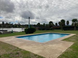 una piscina en el césped junto a un lago en Casa en primera línea del Lago Rapel, Punta del Sol, en Las Cabras