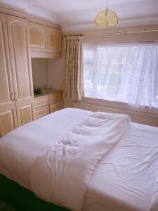 1 dormitorio con cama blanca y ventana en God’s Abode, en Windsor