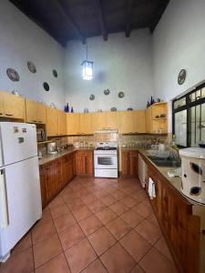 a large kitchen with wooden cabinets and a white refrigerator at Casa San Miguel in Antigua Guatemala