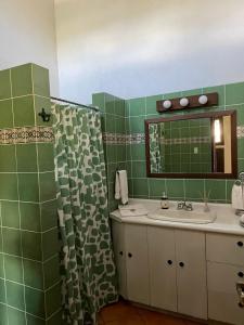 y baño con lavabo y ducha con espejo. en Casa San Miguel en Antigua Guatemala