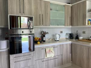 cocina con armarios de madera y microondas en Casa en primera línea del Lago Rapel, Punta del Sol, en Las Cabras