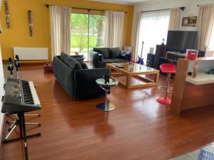 sala de estar con sofá y piano en Casa en primera línea del Lago Rapel, Punta del Sol, en Las Cabras